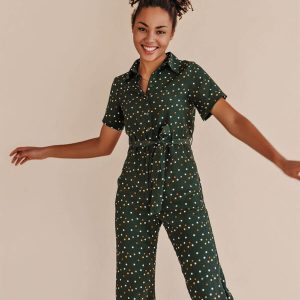 Green jumpsuit with polka dots and a tie waist, featuring short sleeves and a relaxed fit, ideal for casual wear.